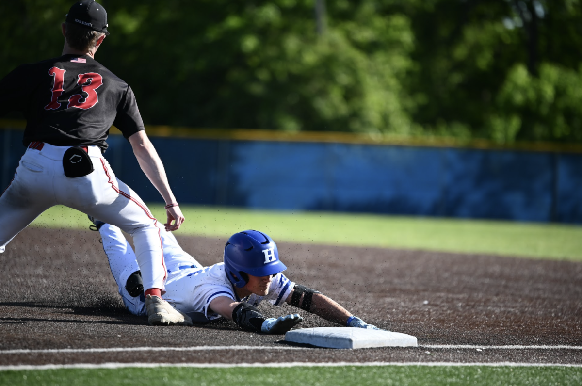 Brooks Hendrix (11) slides in to first base on a pickoff. 